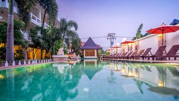 Una piscina al aire libre, sillones reclinables de piscina