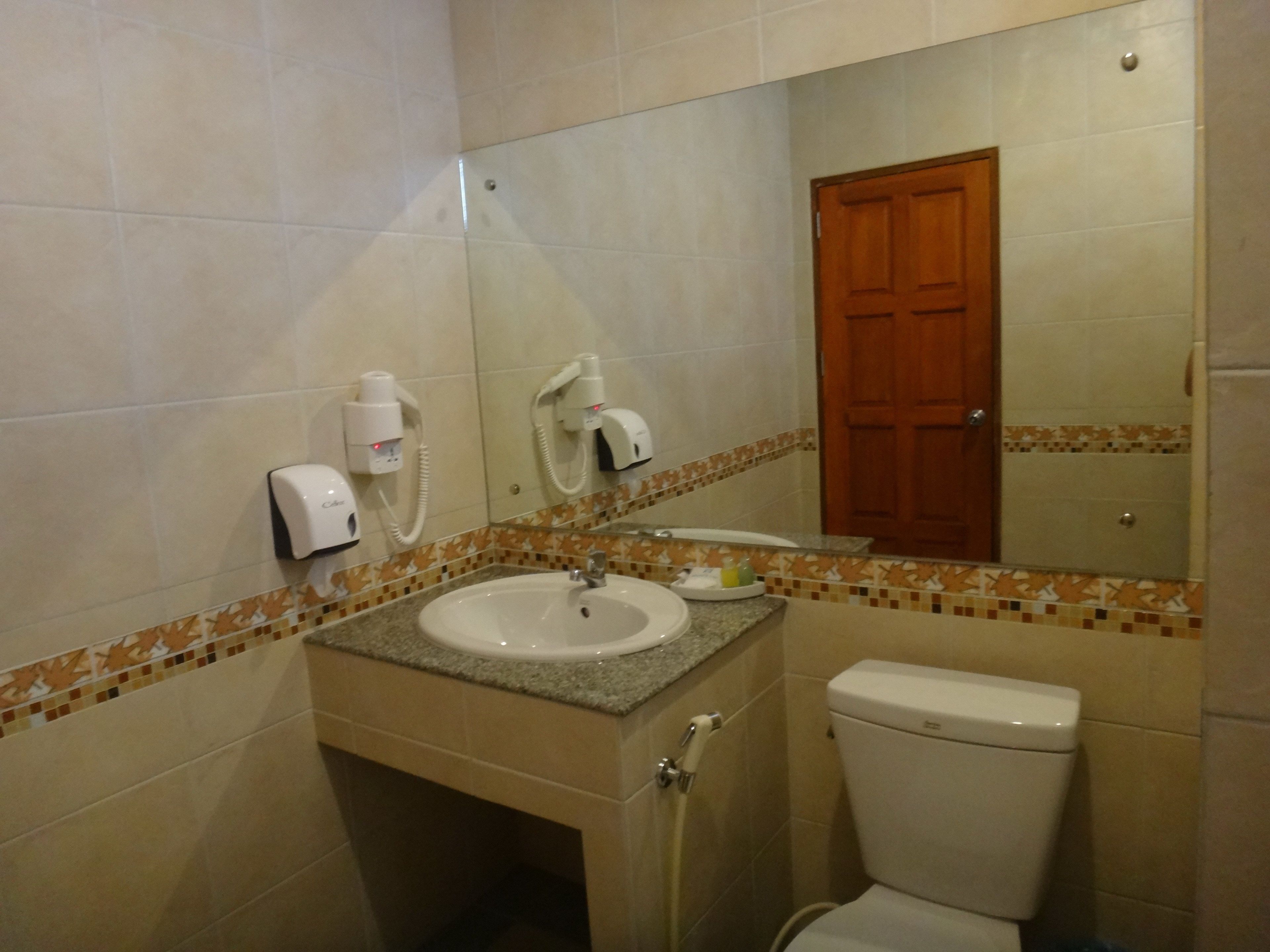 Ein Badezimmer mit Waschbecken, Spiegel und Toilette.