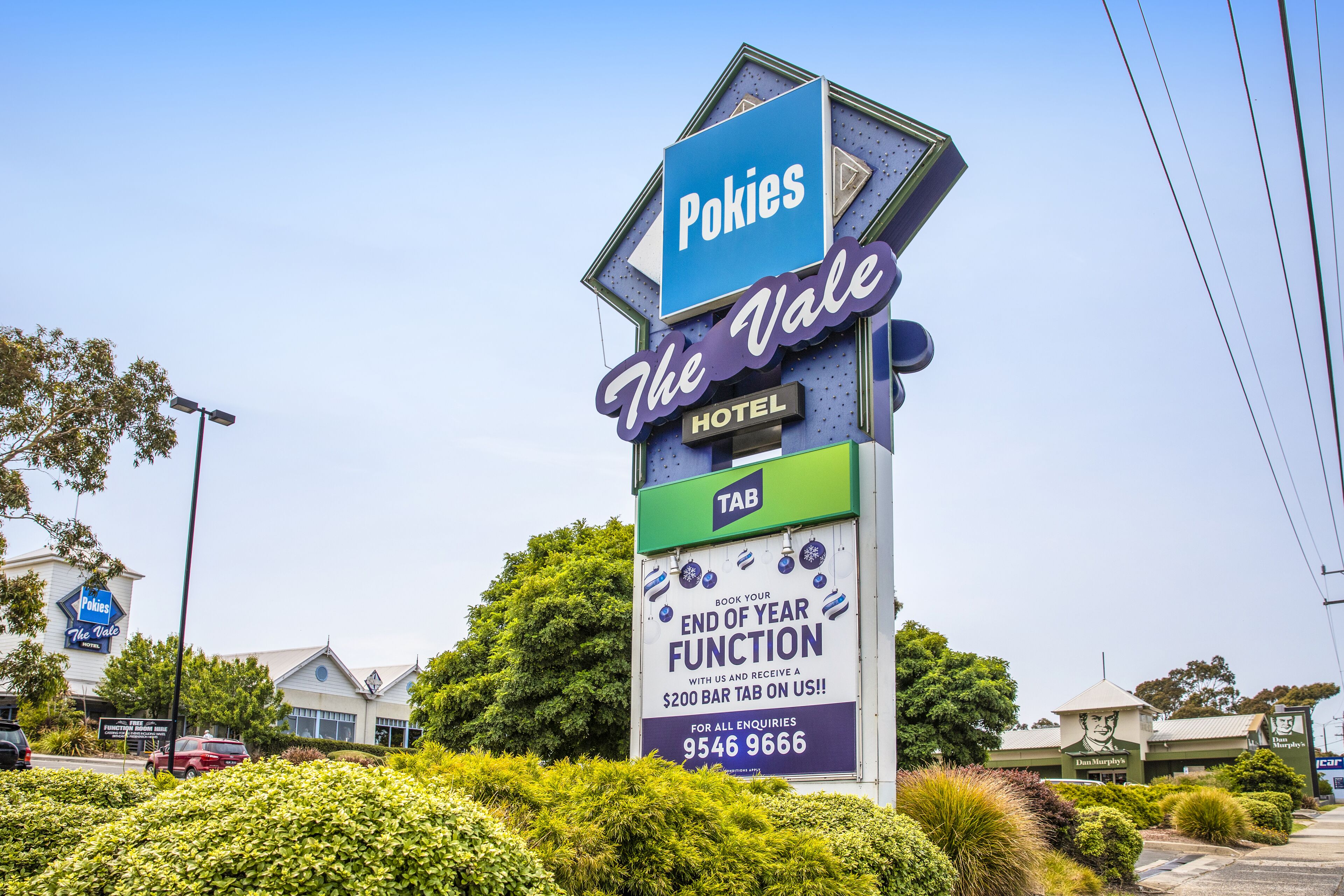 A hotel sign with "Pokies The Vale" and "TAB" branding, promoting end of year function and contact number.