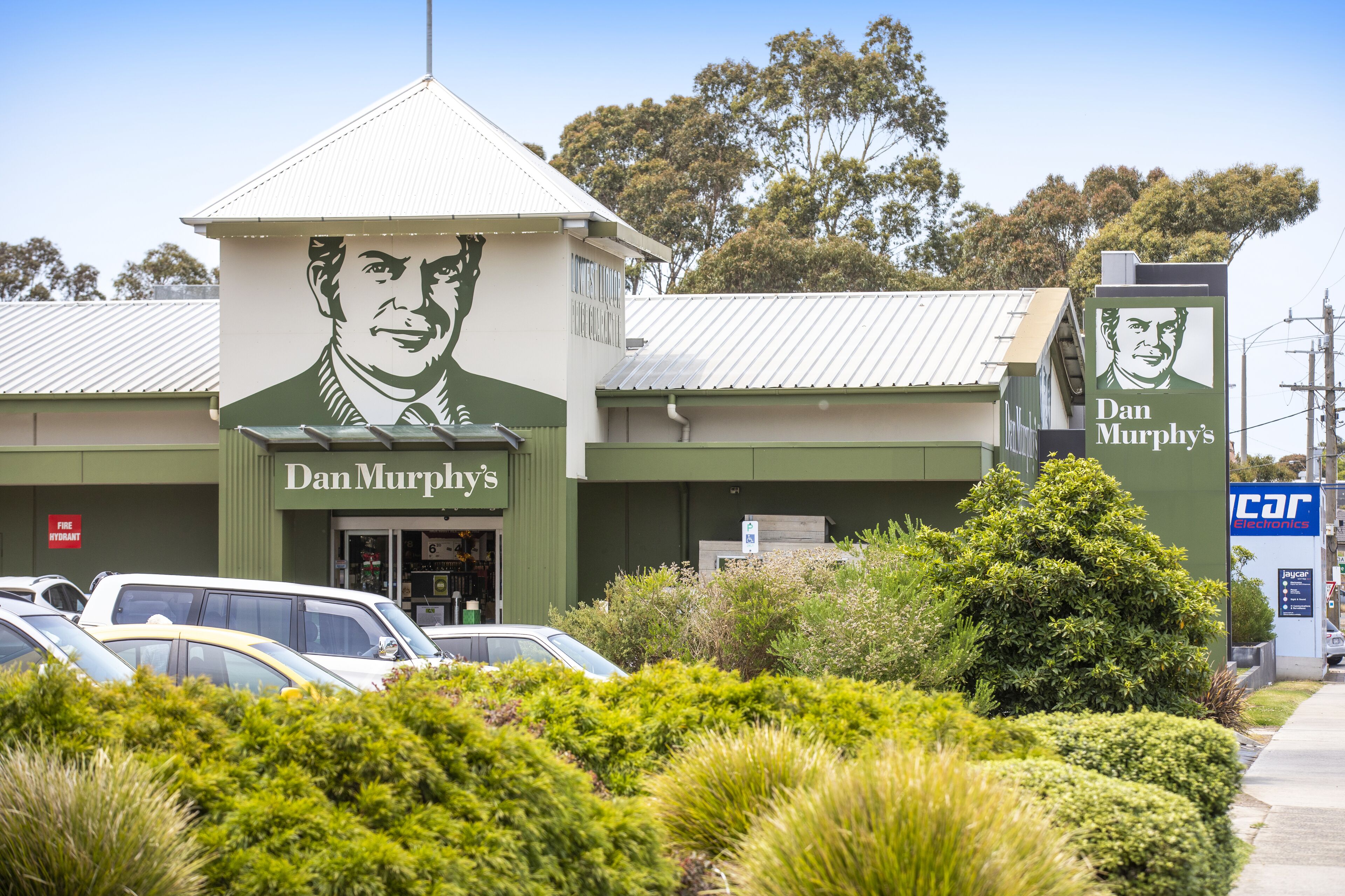 A building with a green facade and a large portrait mural.