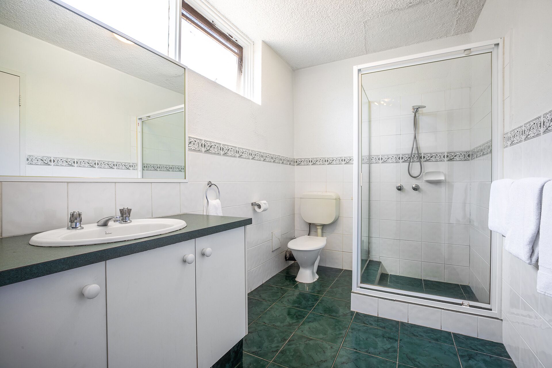 A bathroom with a sink, toilet, and shower.