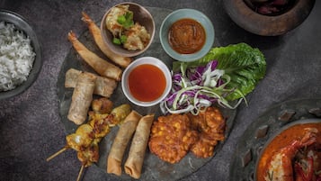A variety of Asian dishes including spring rolls, shrimp, and a bowl of rice.