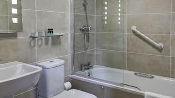 Une salle de bain moderne équipée de toilettes, d’un lavabo et d’une baignoire.