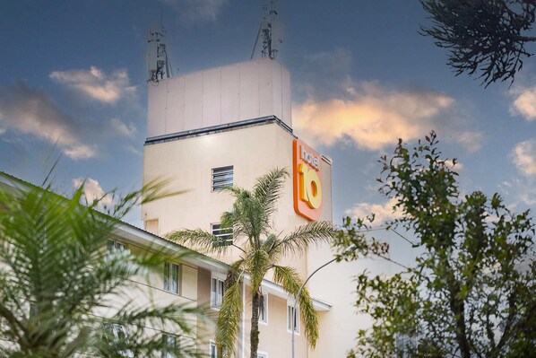 Un edificio de hotel con un letrero llamativo, techo plano y cielo despejado.