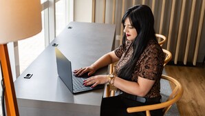 A person seated at a table with a laptop, a smartphone, and a watch on the table. - Hotel 10 Curitiba (Curitiba)