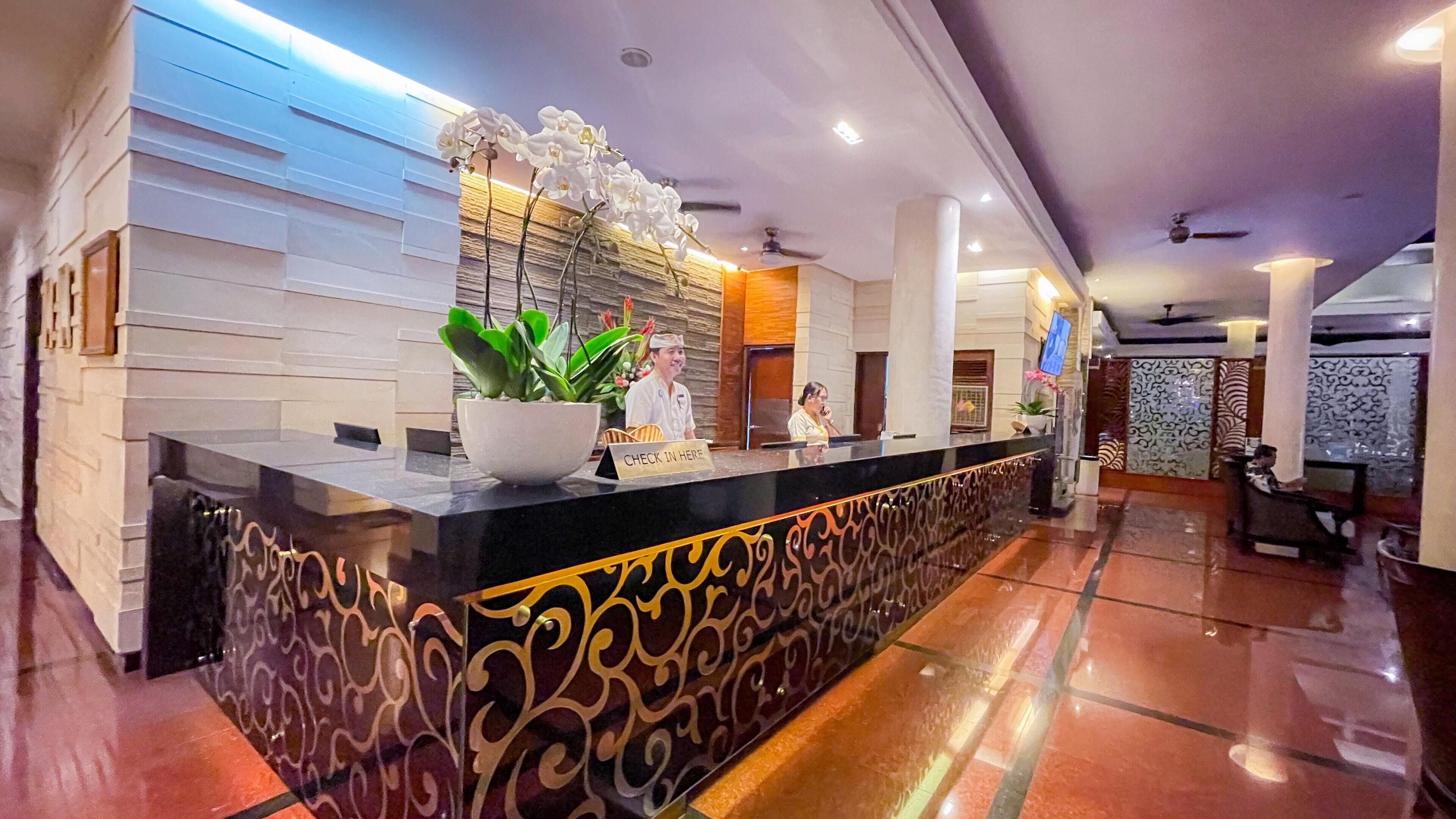 Una hall d'albergo dal design moderno, con una reception, una pianta in vaso e una segnaletica per il check-in.