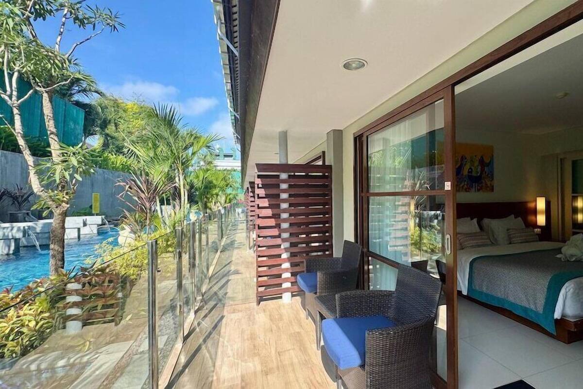 Een balkon met een zwembad, een bed en uitzicht op het zwembad.