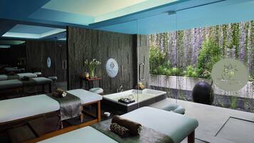 Relax in a serene spa room with a large bathtub, massage tables, and a calming atmosphere.