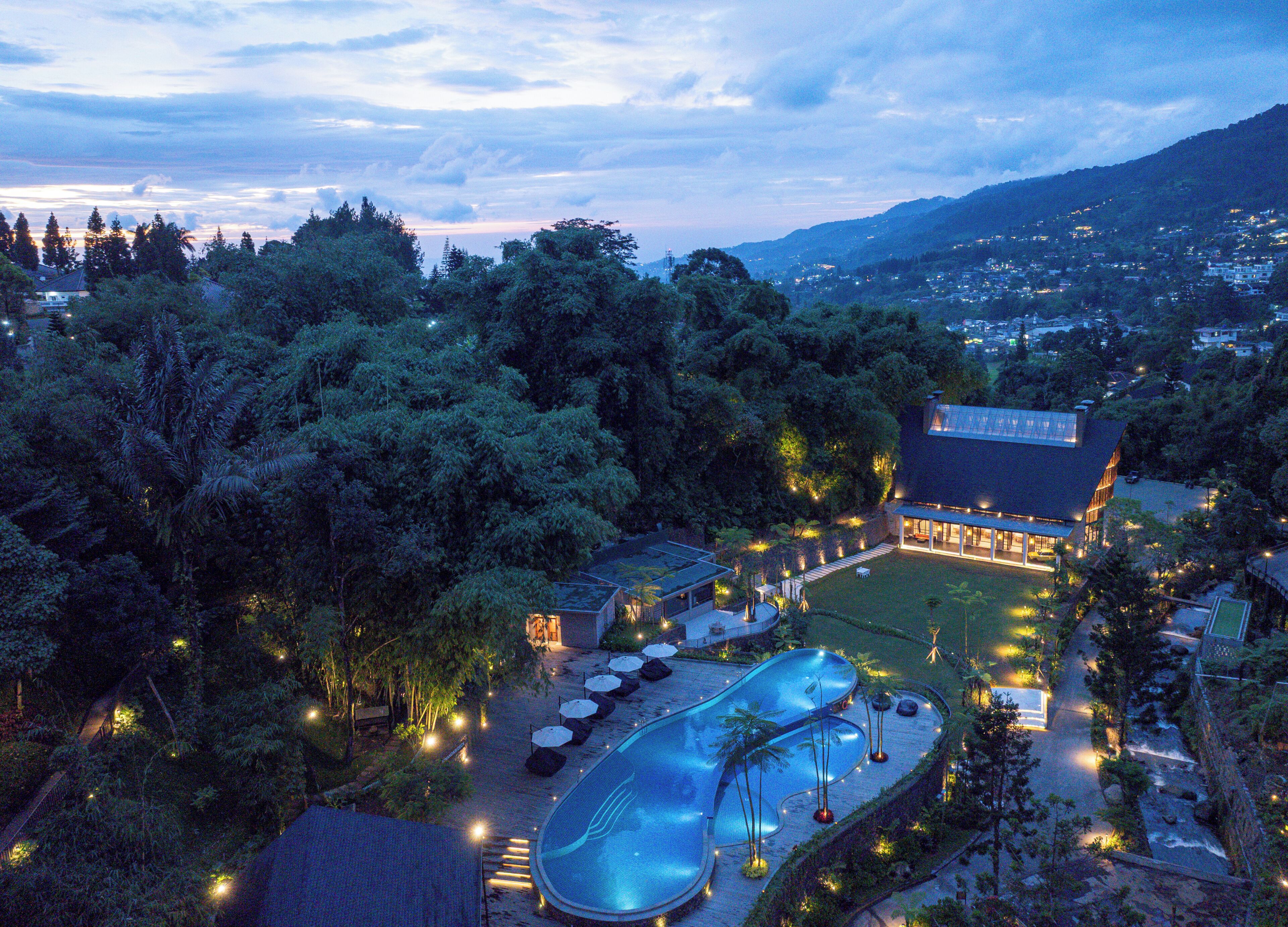 Un resort con piscina, zona de estar y un edificio grande de techo plano.
