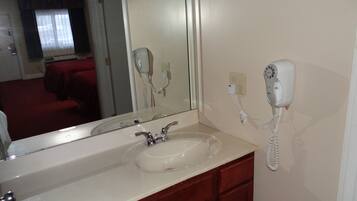 A bathroom with a sink, mirror, and hairdryer.