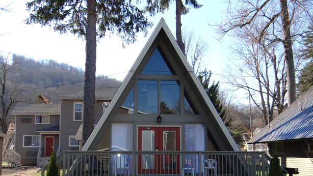 Un edificio de forma triangular con una puerta roja y un balcón.