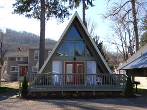 A triangular-shaped building with a red door and a balcony.