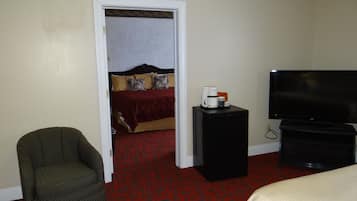 Une chambre d’hôtel équipée d’un lit, d’une télévision, d’une machine à café et d’une chaise.