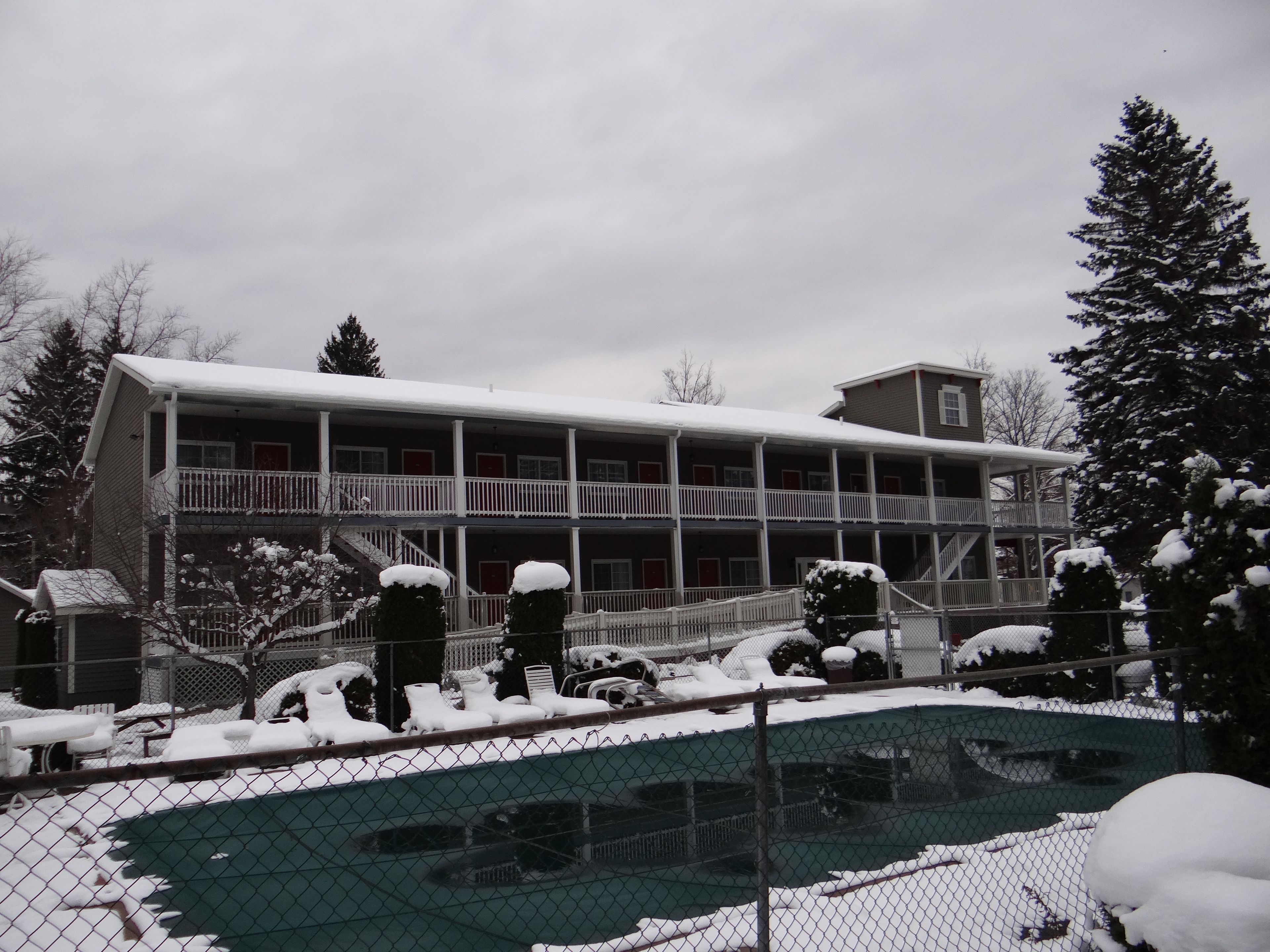 Un bâtiment à deux étages doté d’un balcon couvert et d’une piscine clôturée.