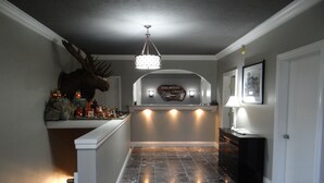 Un área de recepción con piso de mármol, una cabeza de alce montada, un candelabro y un letrero que dice "Edelweiss Lodge".