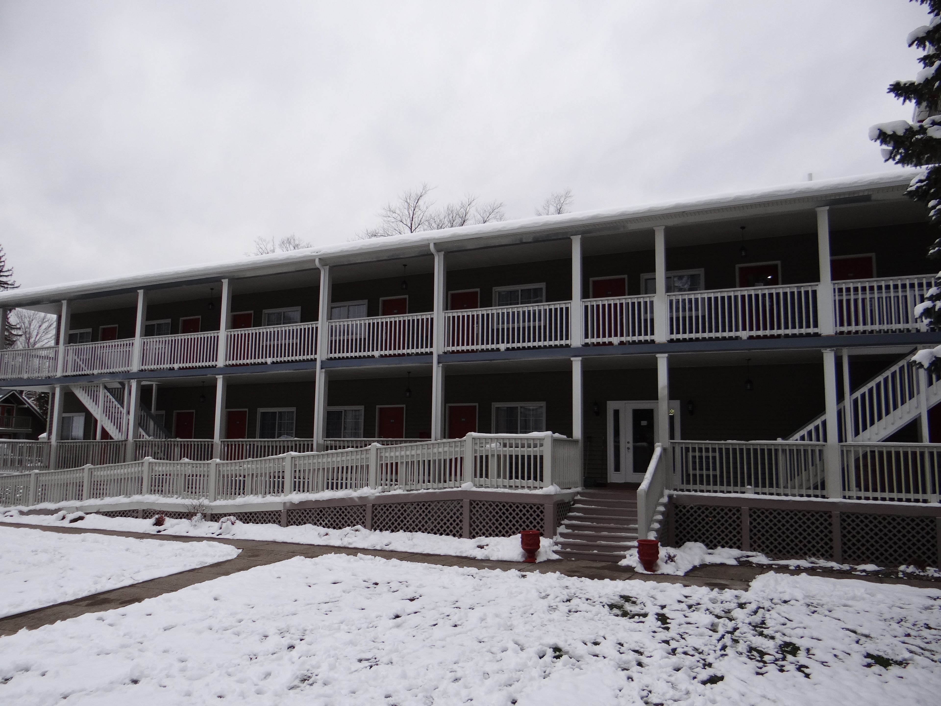 A multi-story building with balconies and a covered entrance.