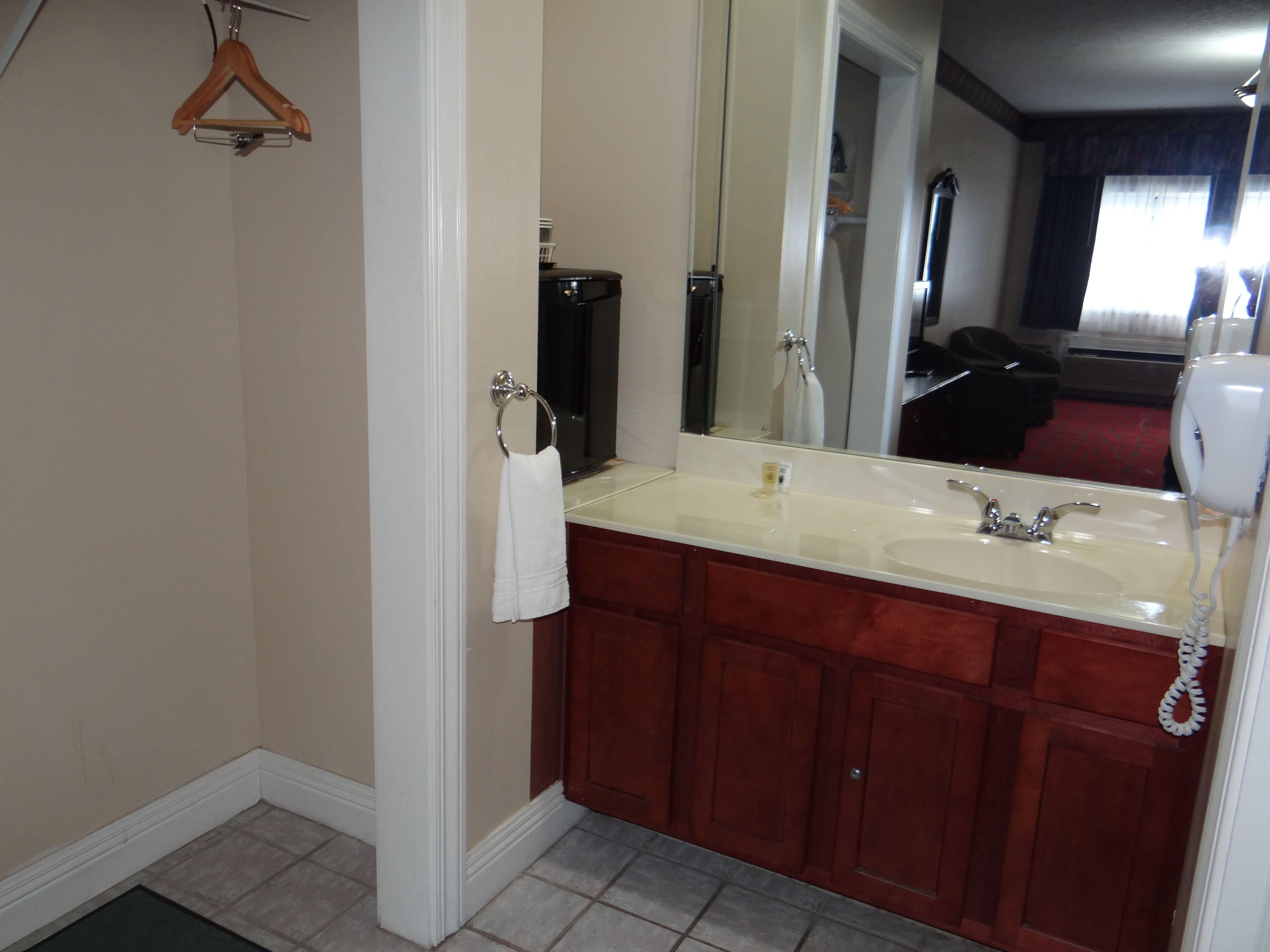 A bathroom with a sink, mirror, and a hanging towel.