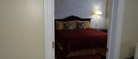 A hotel room with a bed, a nightstand, and a lamp.