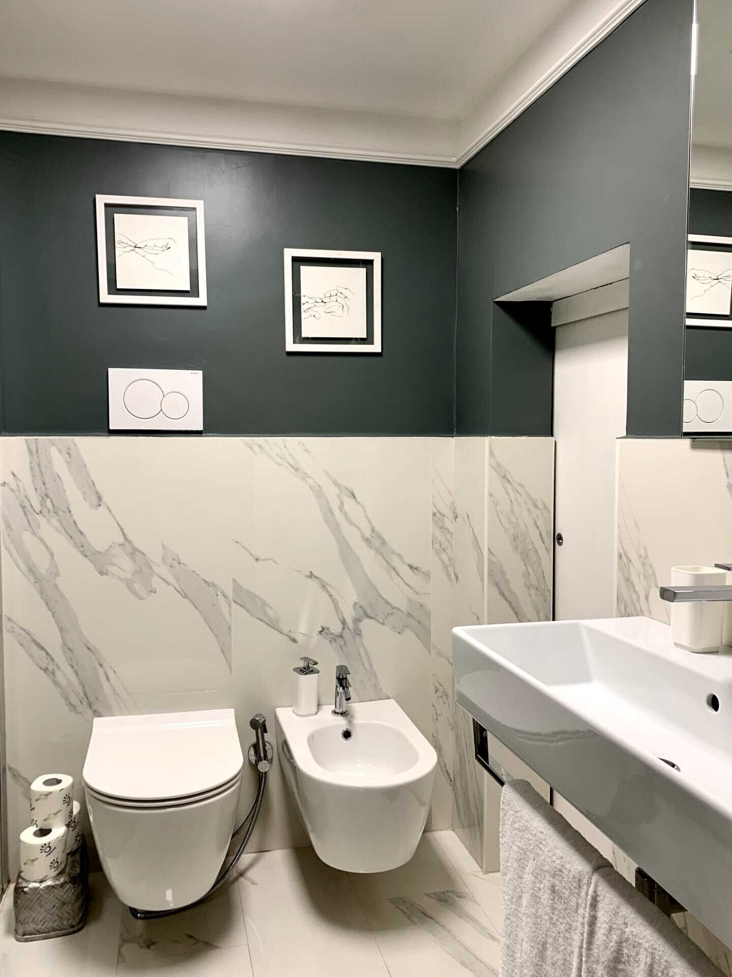 A modern bathroom with a toilet, bidet, and sink.