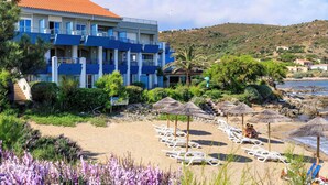 A hotel with multiple balconies overlooking a beach, surrounded by greenery and a clear sky. - Best Western Premier Santa Maria (L'Île-Rousse)