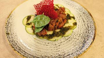 Un plato con un guiso de verduras en rodajas y un detalle decorativo rojo.
