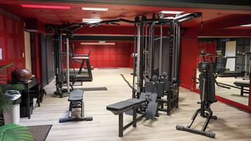 A gym with various exercise equipment, a bench, and a treadmill.