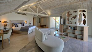 A spacious bedroom with a large bed, a sofa, and a reading area with a bookshelf. - Best Western Premier Santa Maria (L'Île-Rousse)