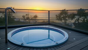 A hot tub with a tiled edge, surrounded by a wooden deck, overlooking a sunset view of the sea. - Best Western Premier Santa Maria (L'Île-Rousse)