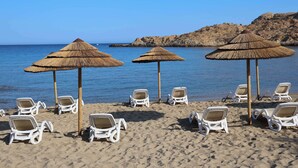 A beach with white lounge chairs and thatched umbrellas. - Best Western Premier Santa Maria (L'Île-Rousse)
