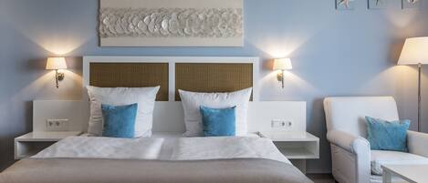 A hotel room with a large bed, two nightstands, a chair, and a wall-mounted artwork.