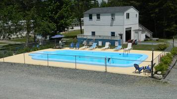 Una piscina al aire libre de temporada, sombrillas