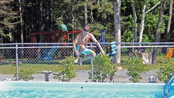 Guests can enjoy a refreshing swim in the pool surrounded by a scenic outdoor setting.