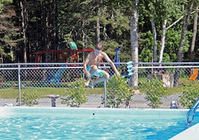 Una piscina al aire libre de temporada, sombrillas, tumbonas