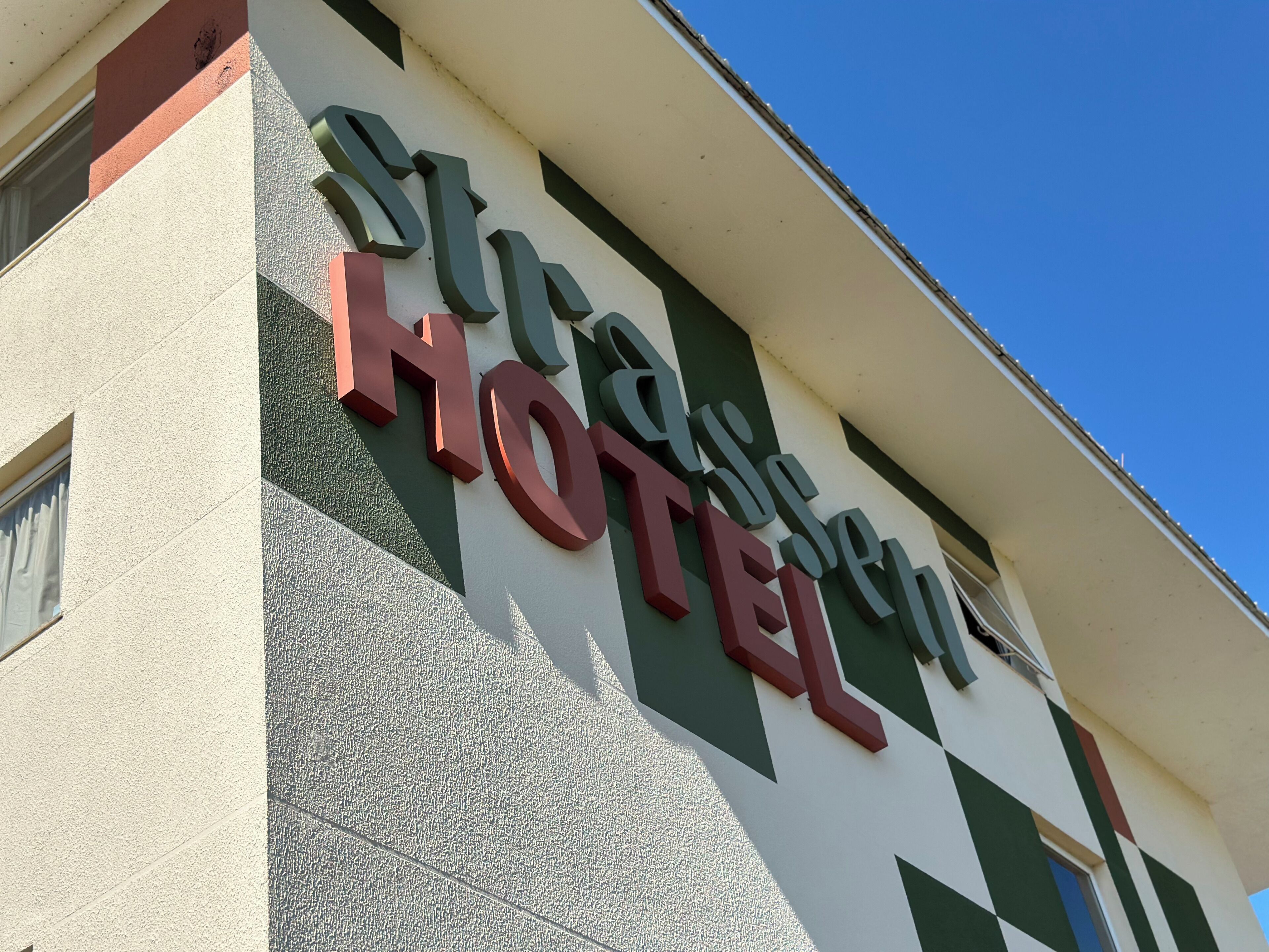Une enseigne d’hôtel avec le nom « Stras Hotel » écrit en grandes lettres bien visibles.