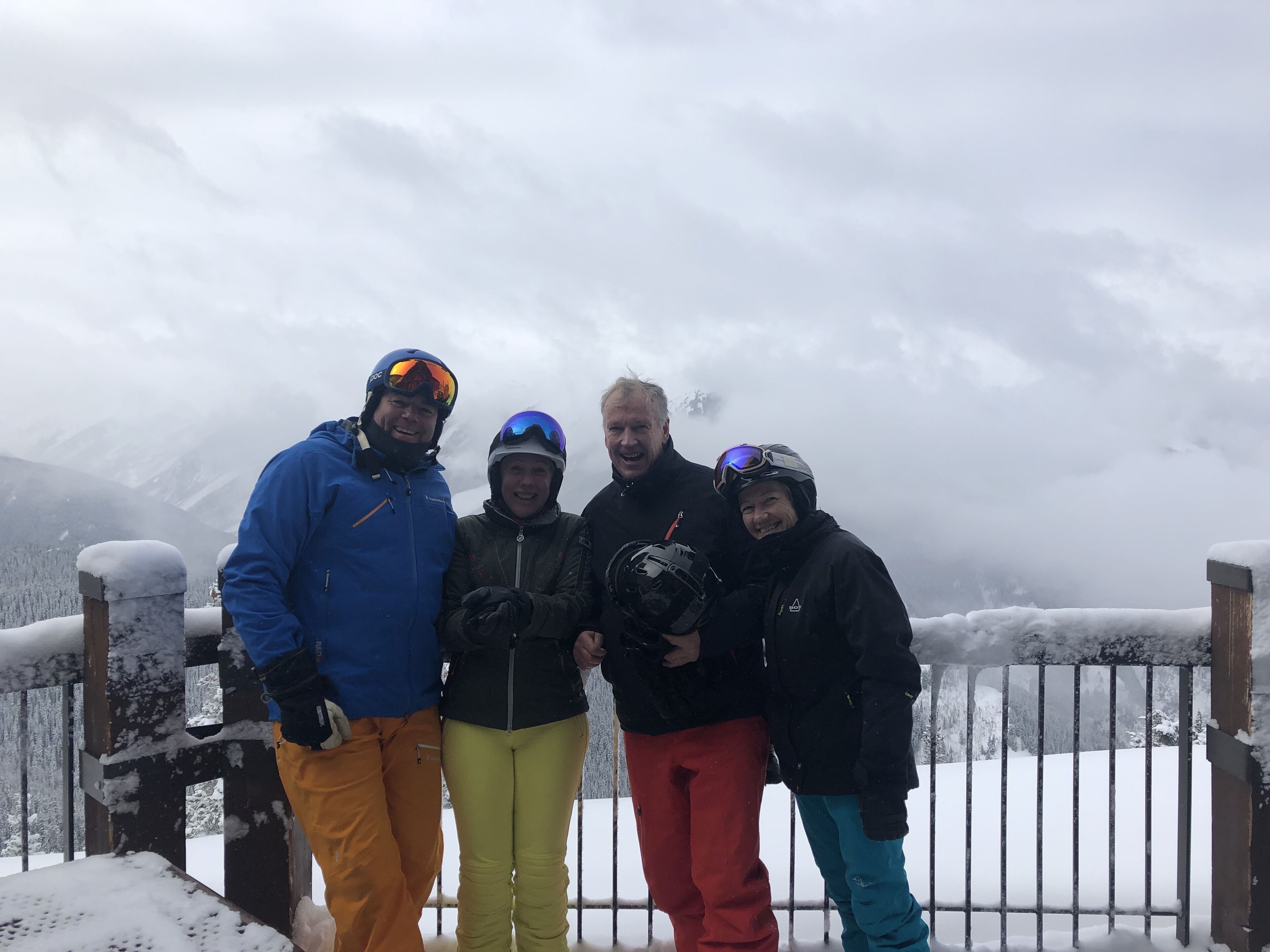 Un gruppo di persone su una piattaforma innevata con vista su una montagna sullo sfondo.
