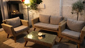 Ein gemütlicher Außenbereich mit Korbmöbeln, einem Tisch und einer Lampe.