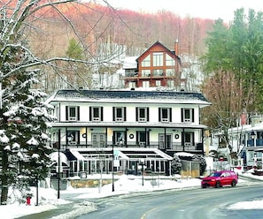 A two-story hotel with a symmetrical facade, large windows, and a central entrance.