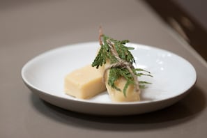 A white plate with a piece of food and a sprig of greenery.