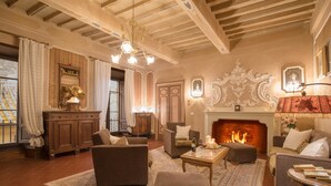 Un salón acogedor con chimenea, asientos cómodos y un espejo decorativo.