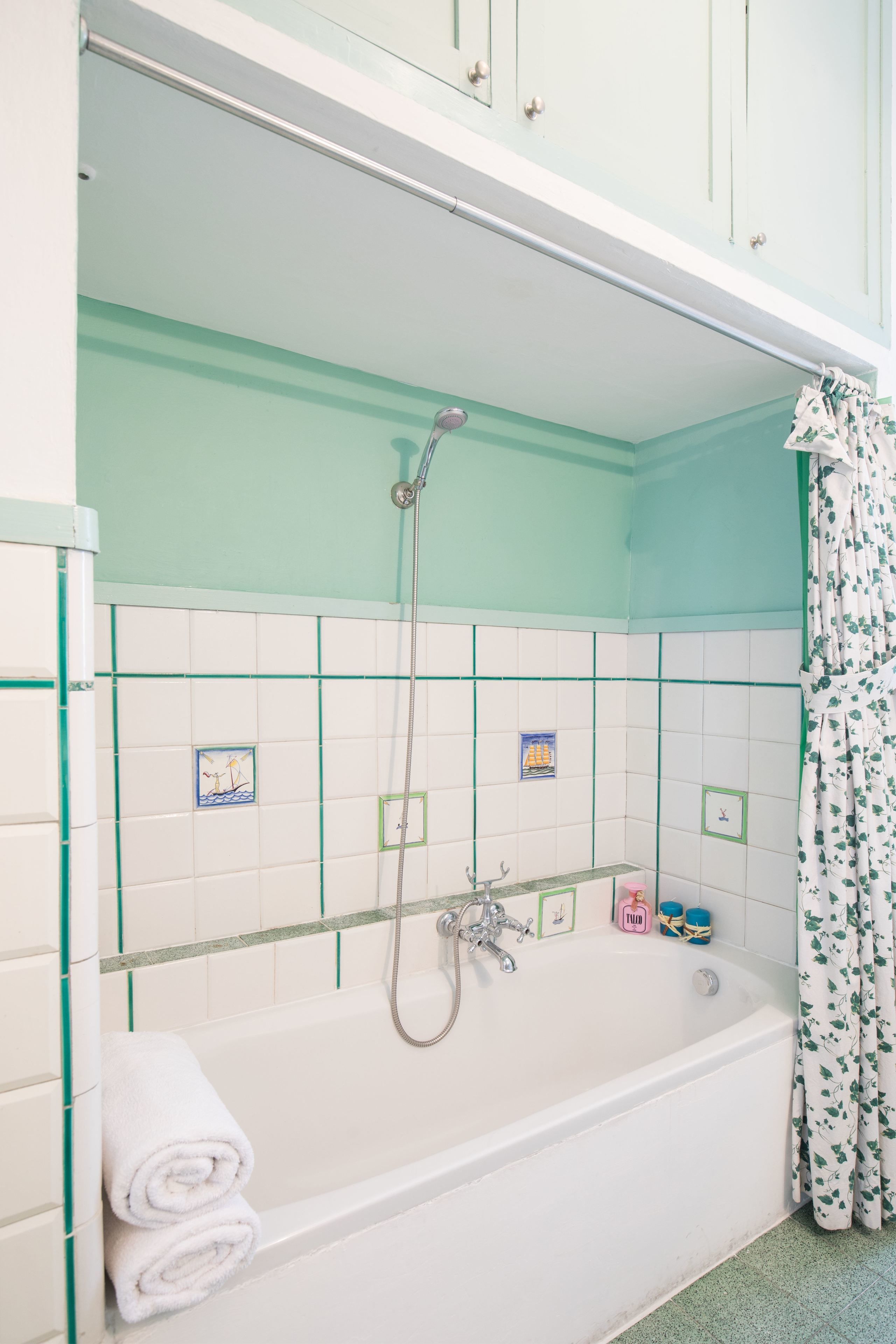 Une salle de bain avec une baignoire, une douche et des murs carrelés.