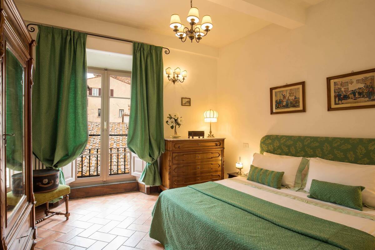 Un dormitorio con cama, cómoda, lámpara y un cuadro en la pared.