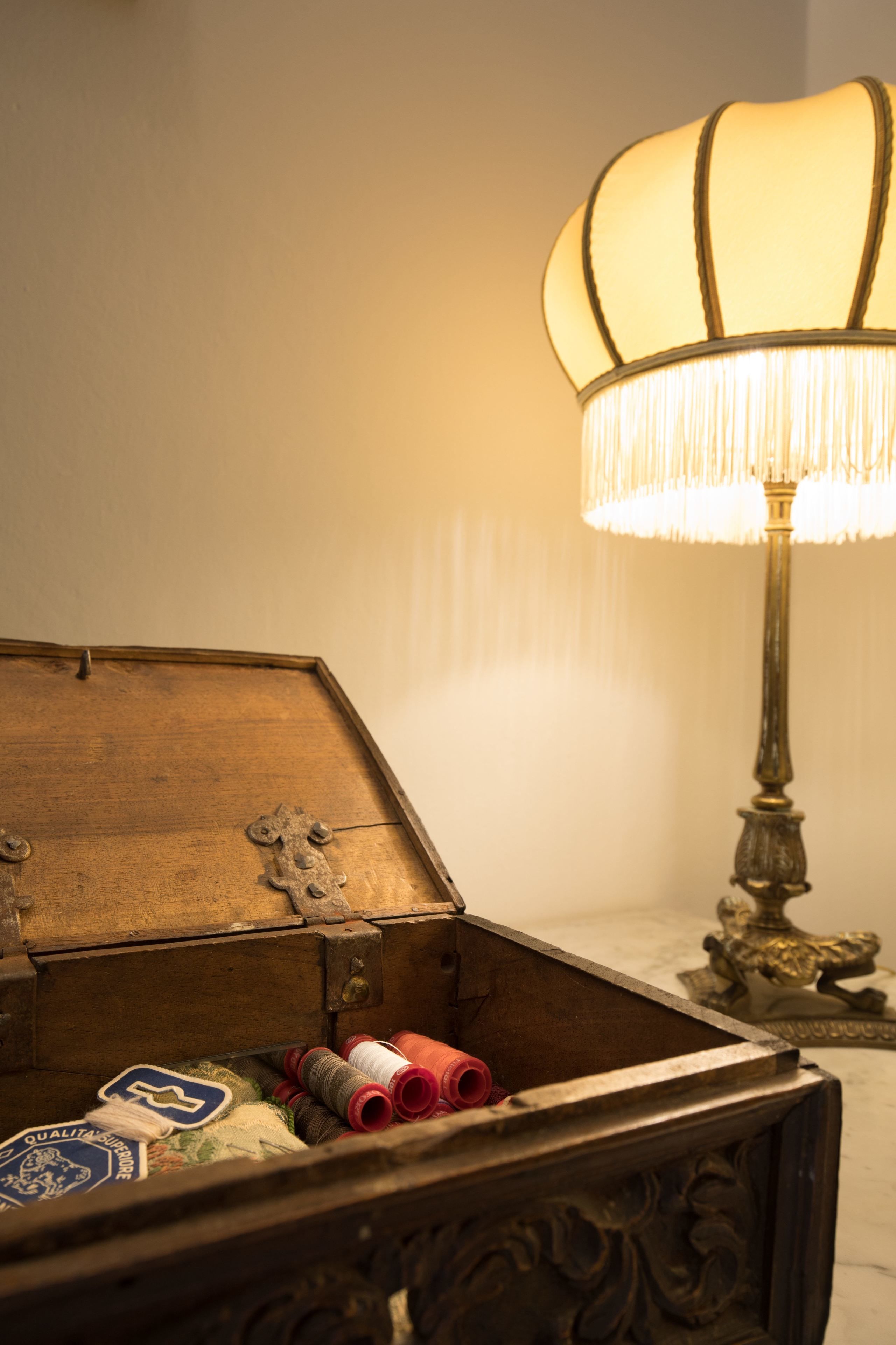 A wooden chest with a brass lamp beside it.
