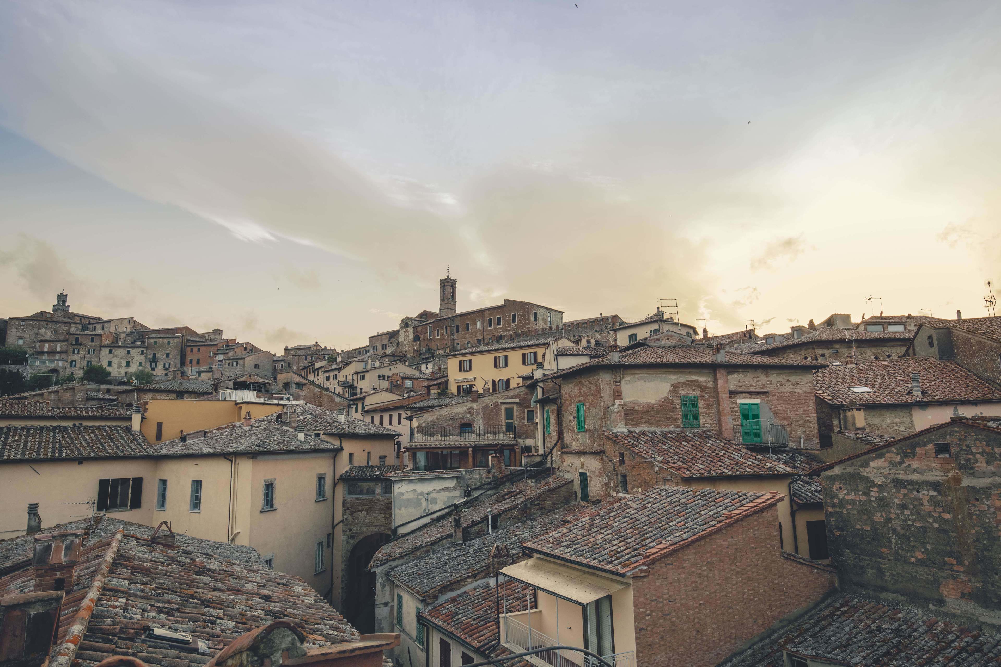 A historic town with closely packed buildings, narrow streets, and a prominent tower.