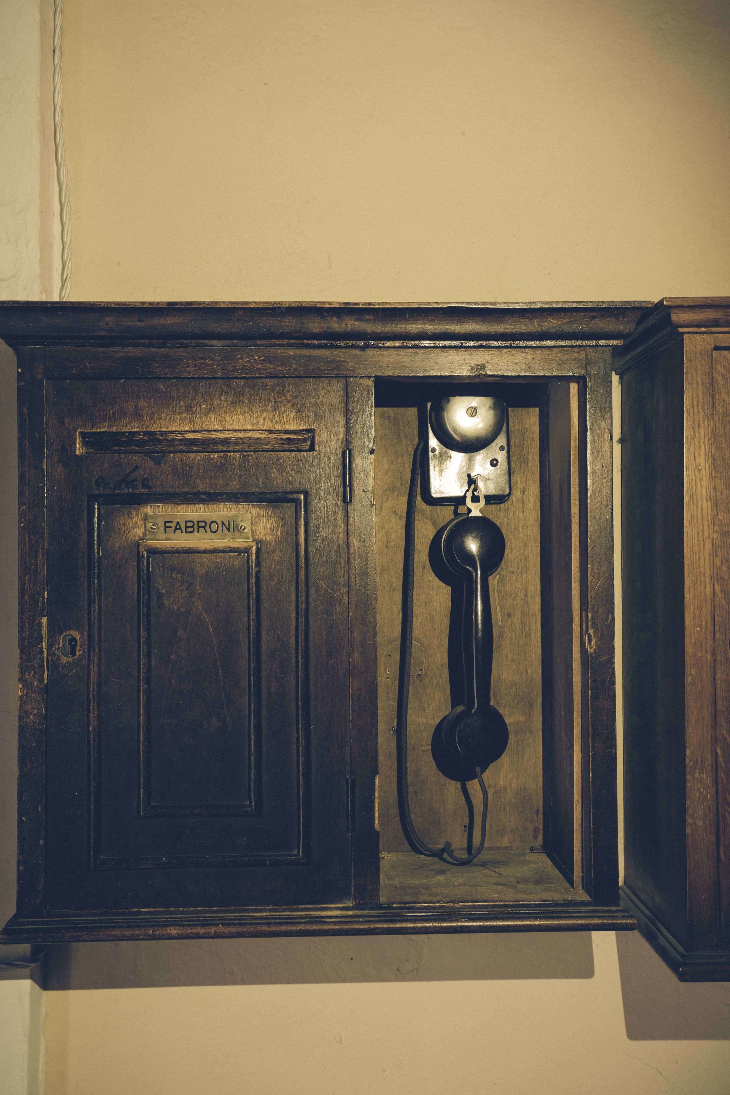Een klassieke telefooncel met een bord waarop staat 