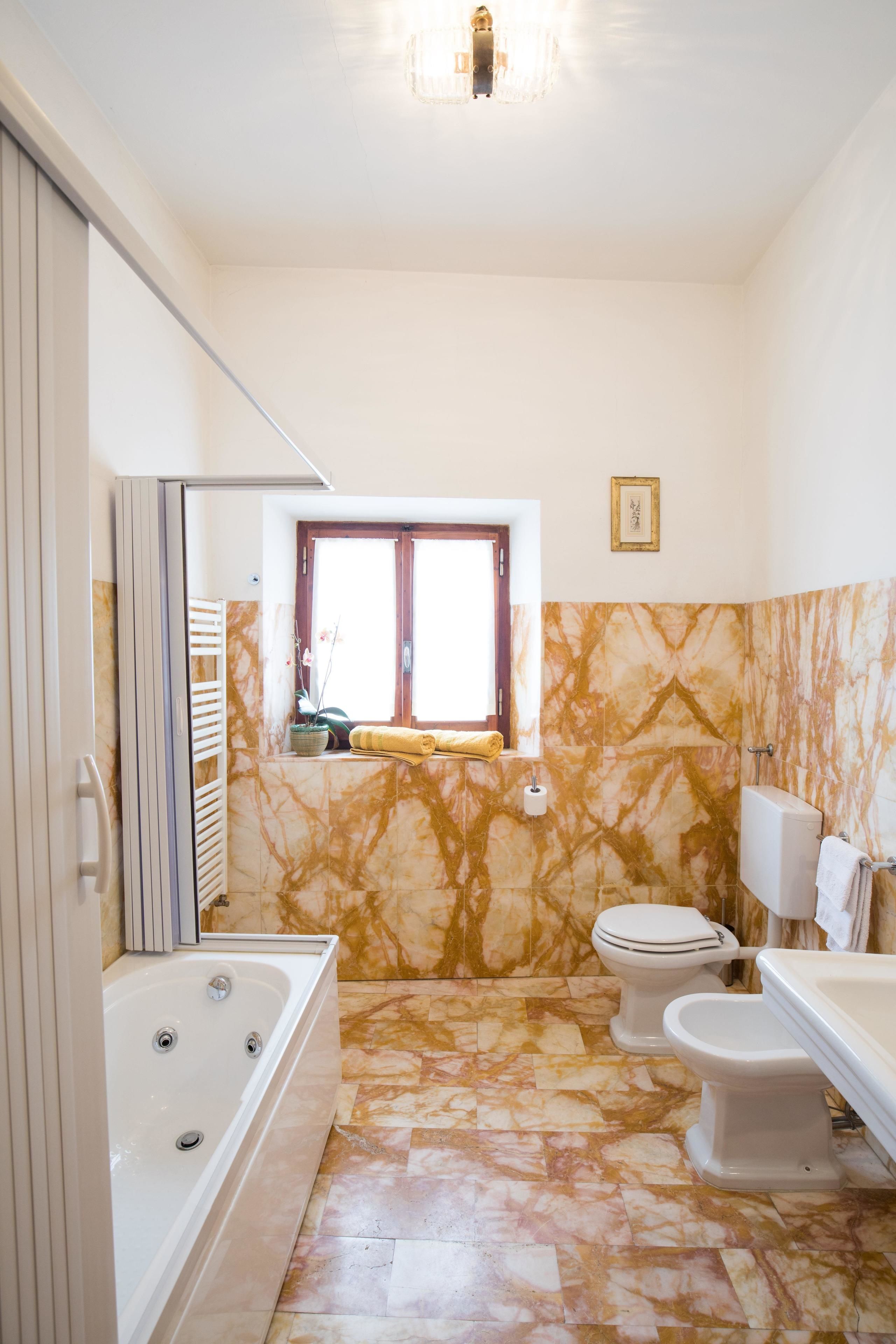 A bathroom with a bathtub, toilet, and sink.