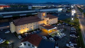Un hotel con un letrero llamativo, un estacionamiento y vistas del entorno.