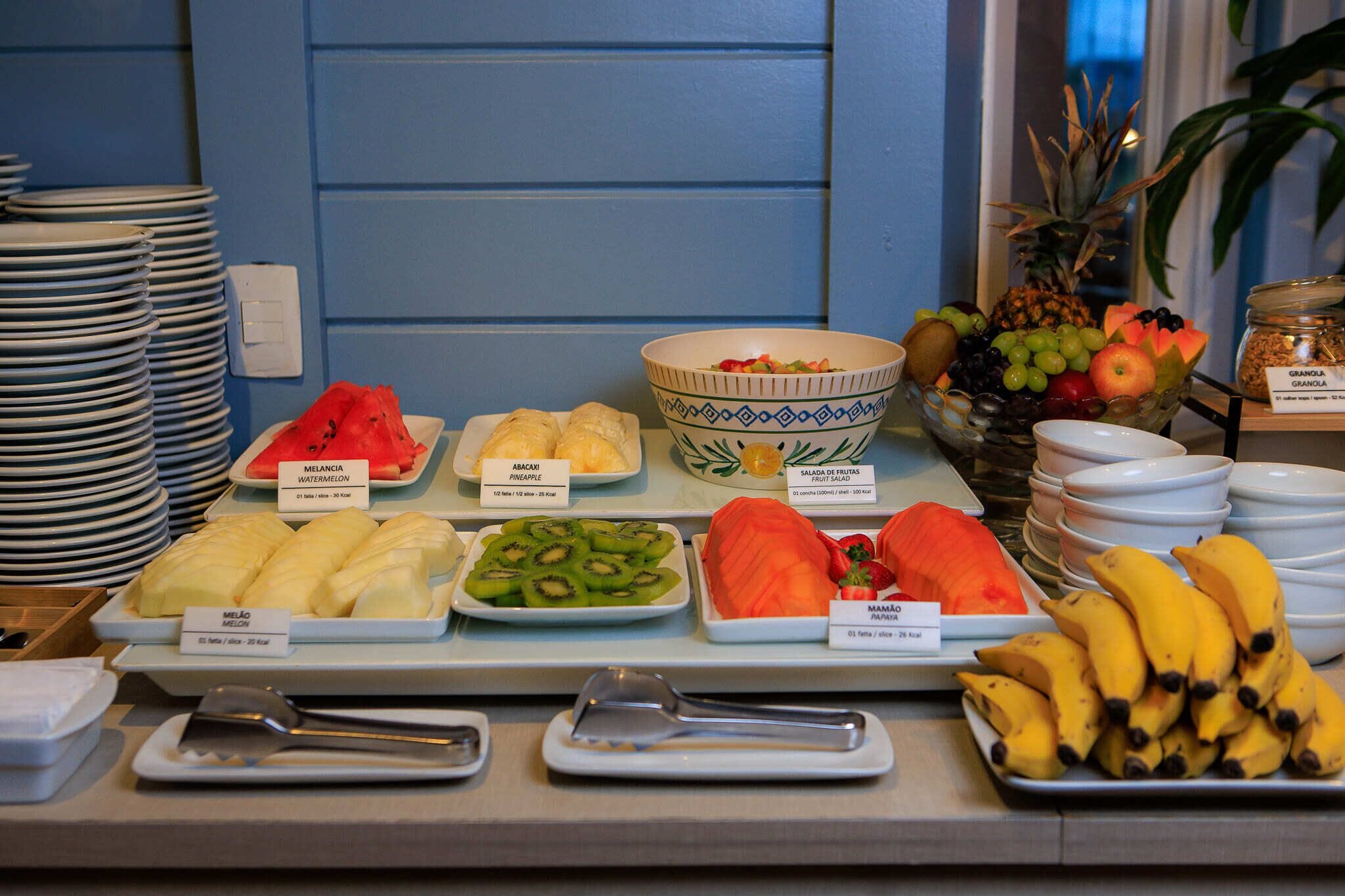 Un bufé de desayuno con diversas frutas, verduras y una selección de panes.
