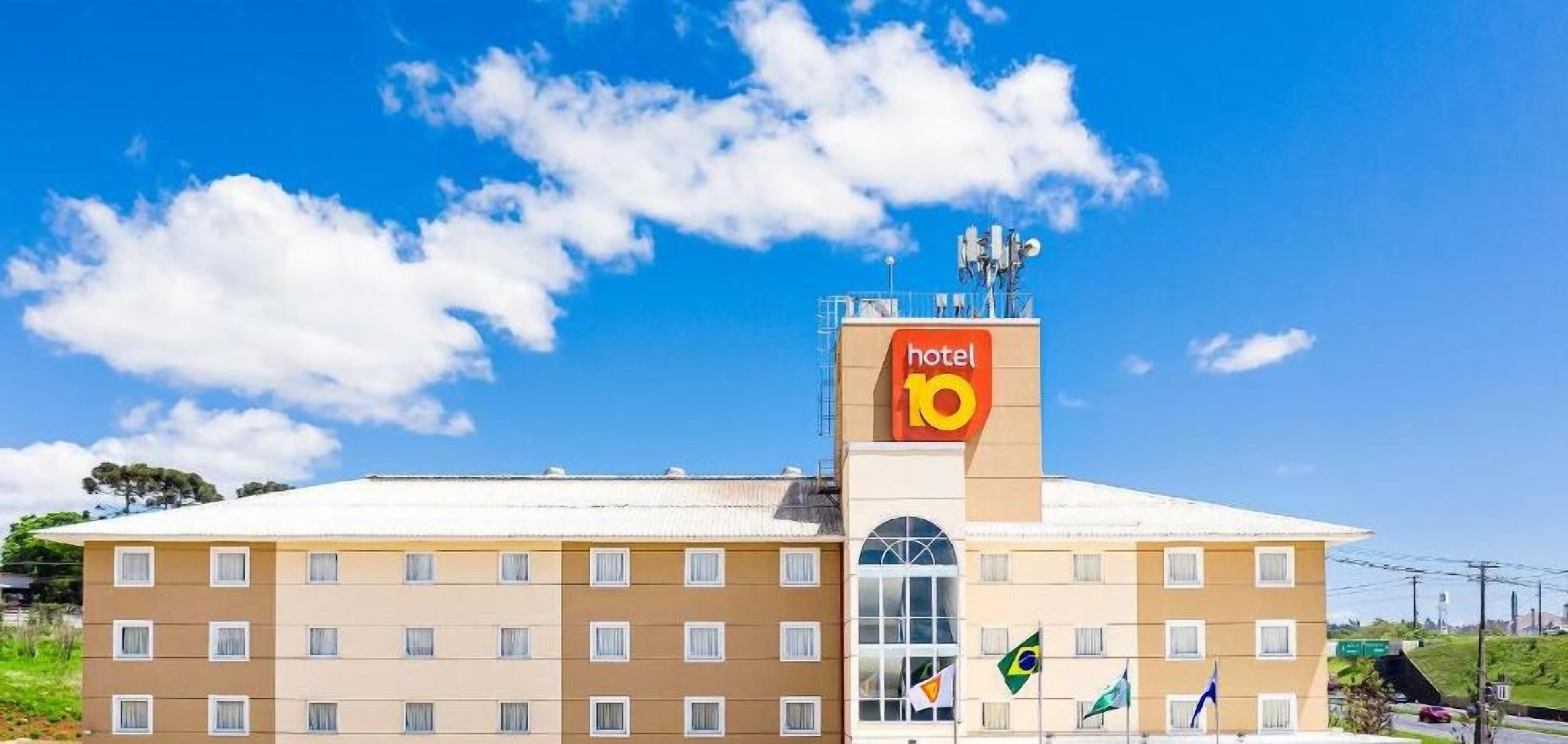 Un edificio di un hotel con un cartello ben visibile 'hotel 10', numerose finestre e bandiere.