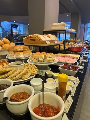 Un buffet proposant une variété de plats, notamment des sandwichs, des gaufres et des sauces.