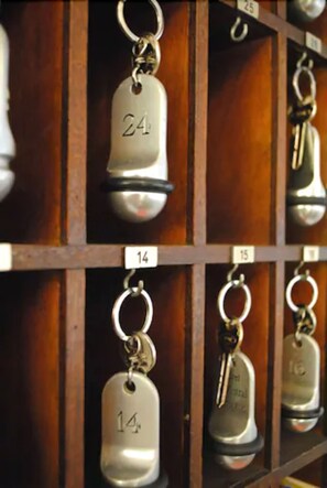 Un ensemble de clés suspendues à un mur en bois, chacune étant munie d’une étiquette numérotée.